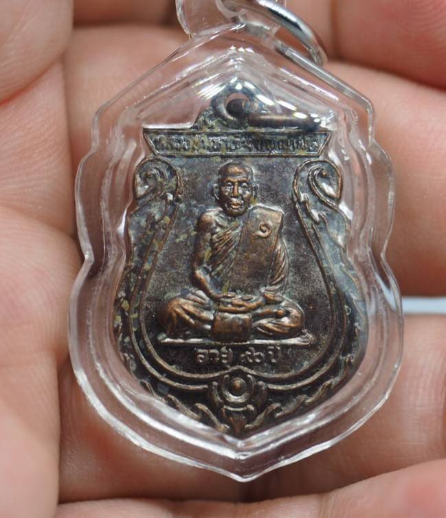เหรียญเสมา รุ่นแรก ( รุ่น 1 ) หลวงปู่มหาเจิม วัดสระมงคล จ.นครปฐม ปี 2549 ( เหรียญเสมาหยุดกระสุน เหรียญประสบการณ์ ) เลี่ยมกันน้ำพร้อมใช้ ด้านหลังติดจีวร กับ เกษาหลวงปู่ พร้อมกล่องเดิม # B